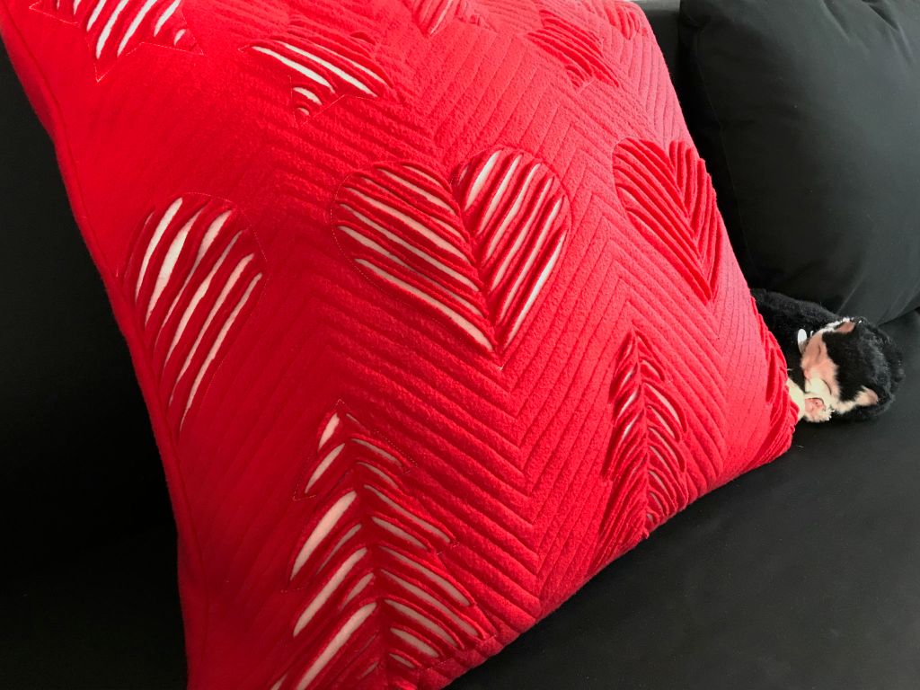 Finished faux chenille Christmas pillowcase on a sofa.
