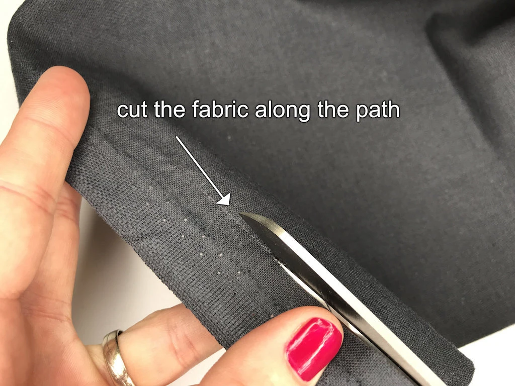 Cutting along the selvedge line following the path created by pulling a lengthwise grain.