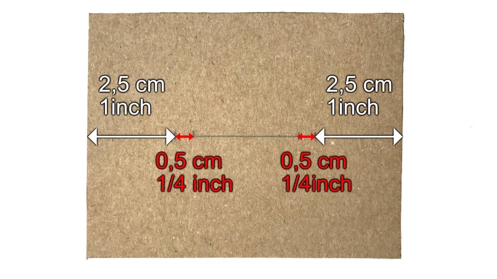 Center line of cardboard bias tape maker with markings for openings.