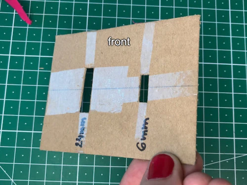 Coating DIY cardboard bias binding tape maker with adhesive tape.