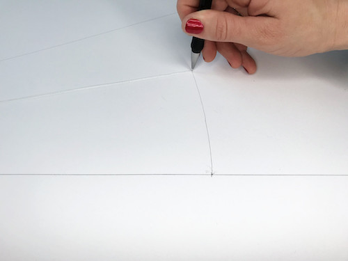 Drawing the hem of a circle skirt with a looped string and pencil.