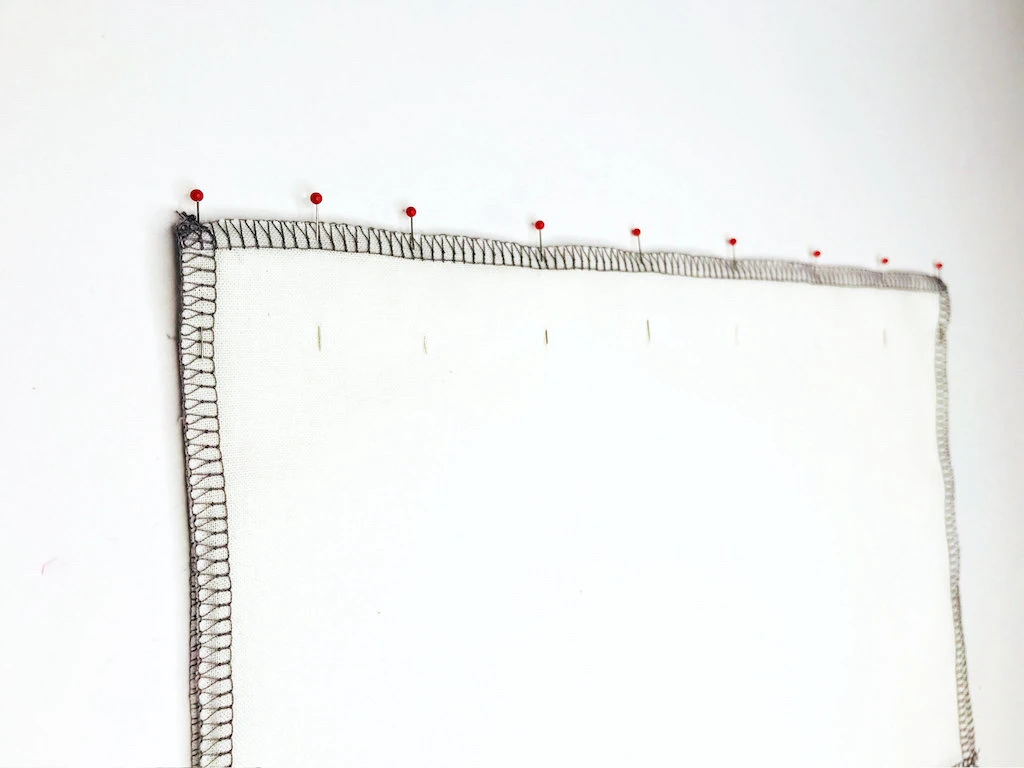 Pattern pieces pinned together perpendicular to seam allowances.
