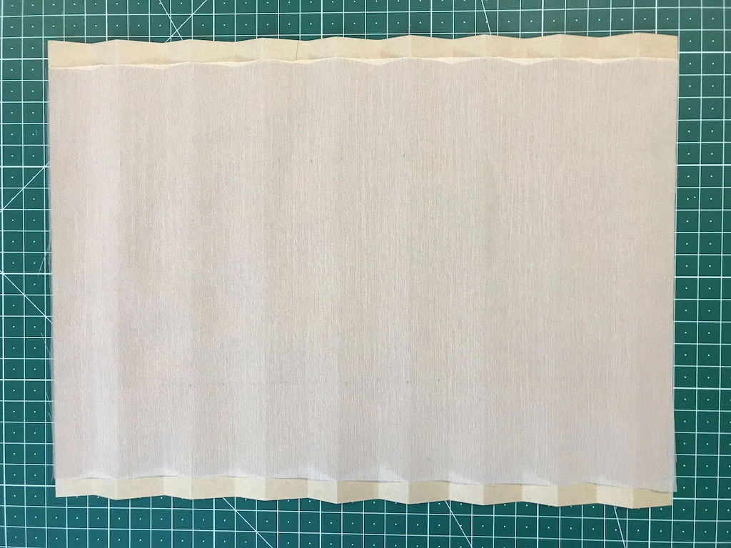Chiffon fabric placed on pleating moulds before applying heat.