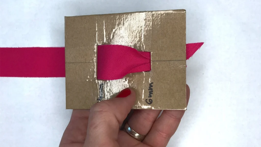 DIY cardboard bias binding tape maker covered with adhesive tape ready to use.