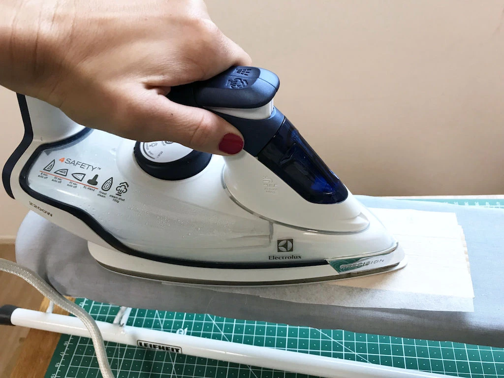 Fixing a fusible interfacing to pleating mould.