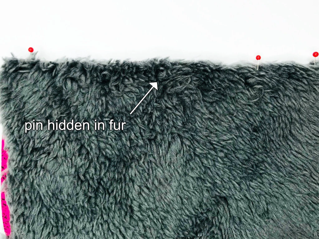 Furry fabric pinned together. Pins perpendicular to fabric edge.
