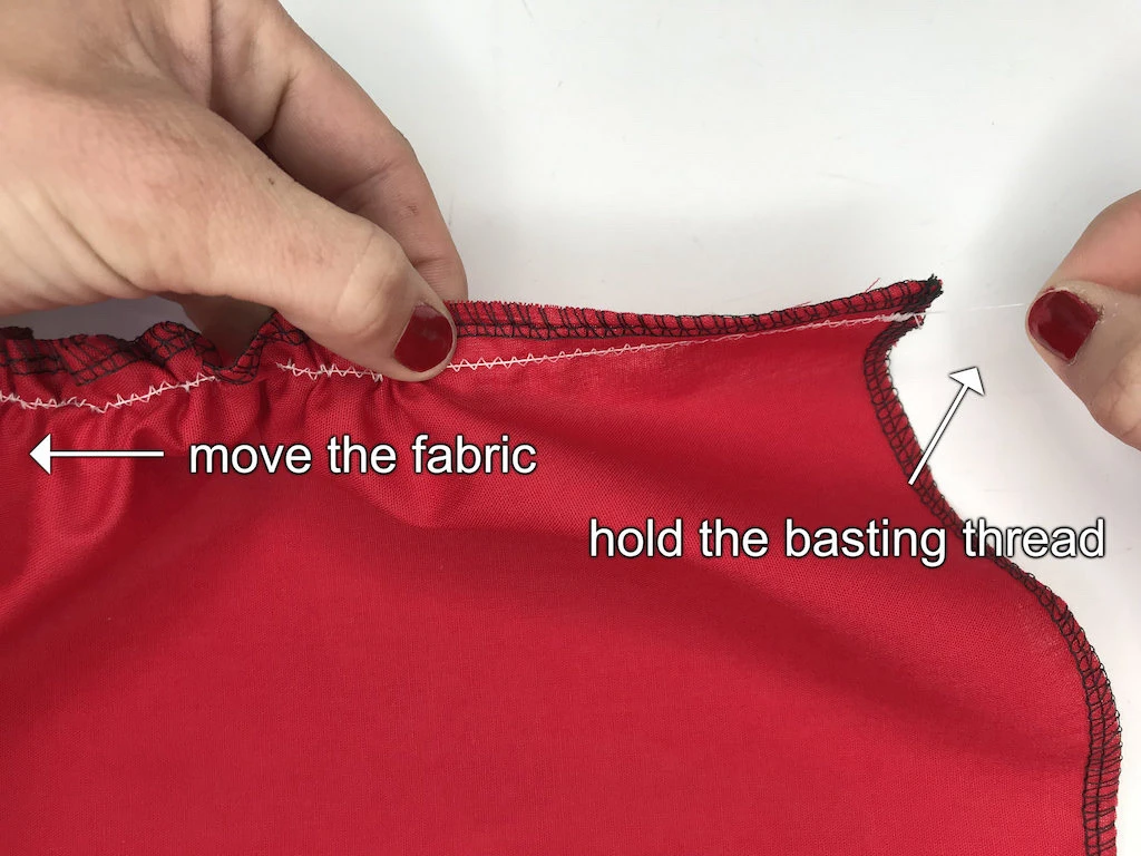 Gathering fabric with the zig-zag stitch by sliding it over a basting thread.