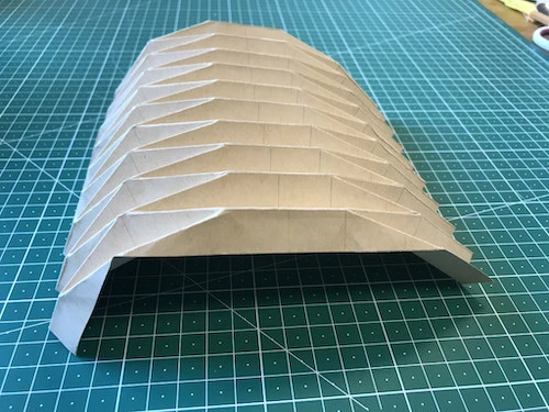 Hand pleated kraft paper in shape of a tunnel.