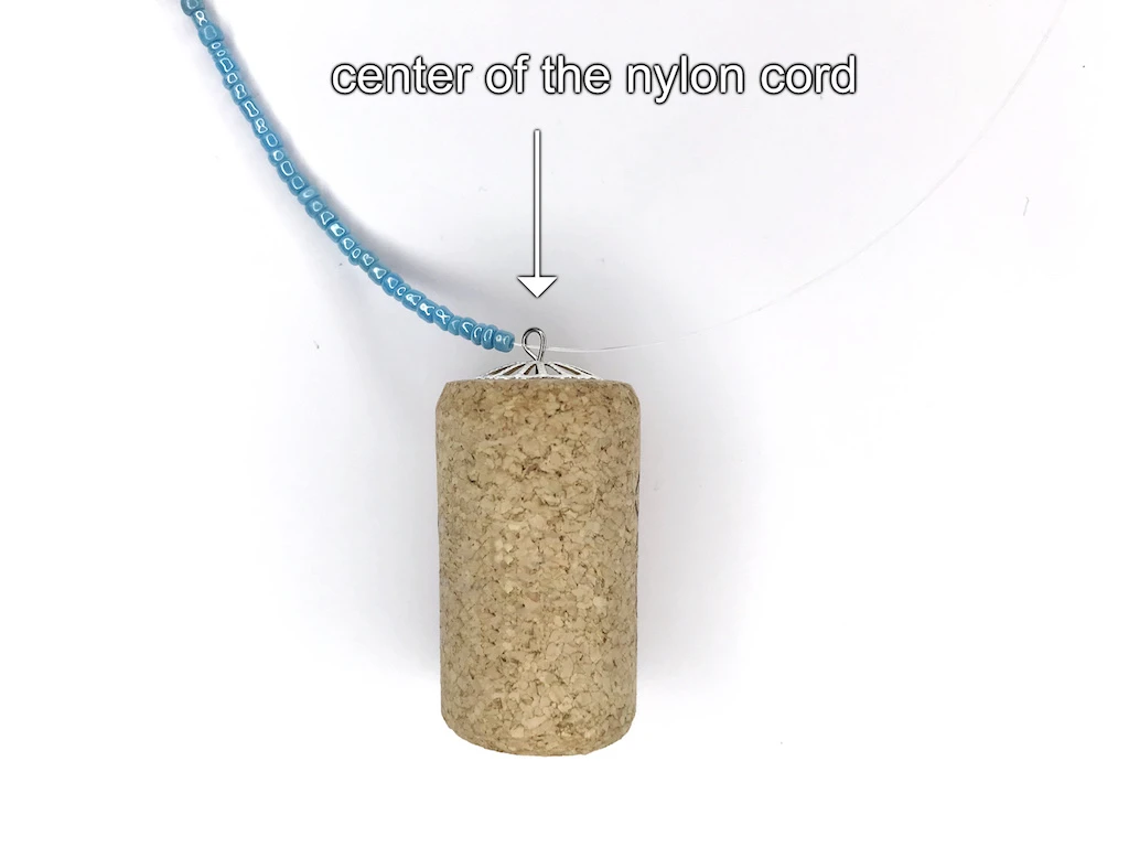 Adding the Luna Lovegood bottle cork pendant into a beaded necklace.