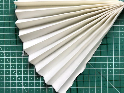 Permanently pleated micro satin fabric. Permanent accordion pleats.