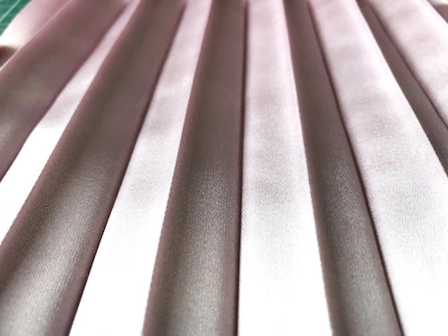 Permanently pleated satin fabric. Permanent accordion pleats.