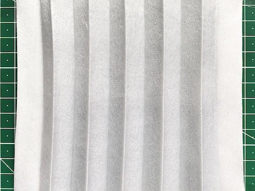 Permanently pleated crepe satin fabric sample. Permanent accordion pleats.