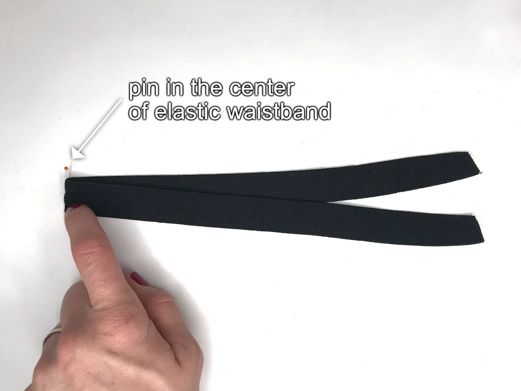Pin in the center of an elastic waistband.