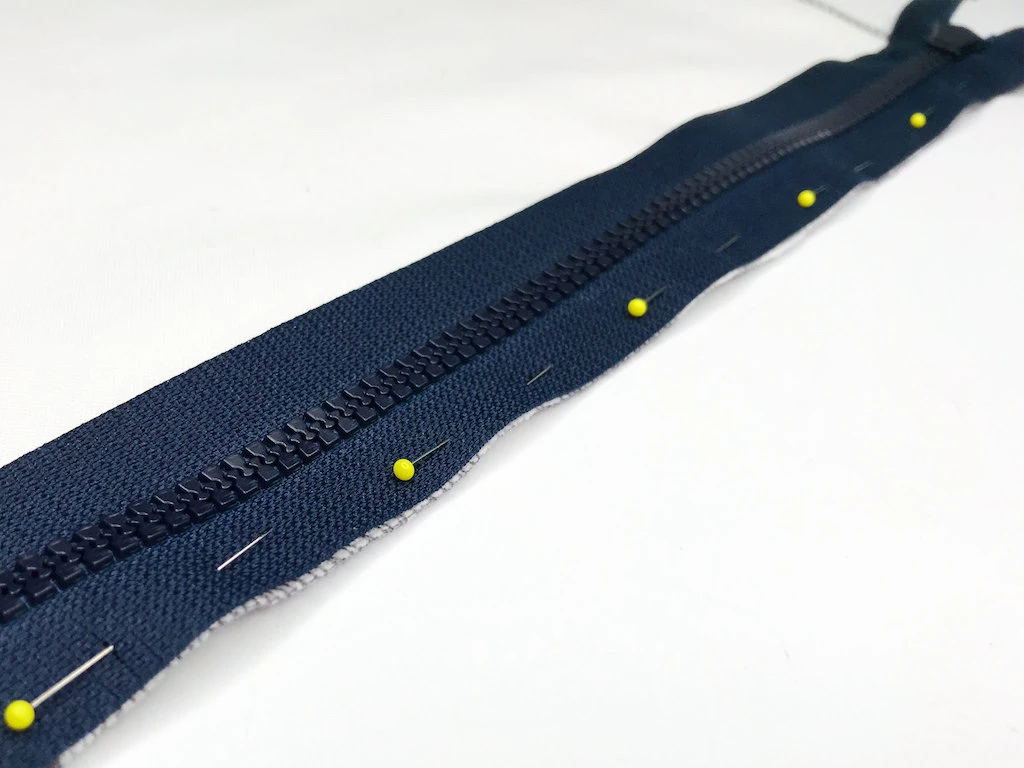 Zipped pinned to a fabric along seam allowance.
