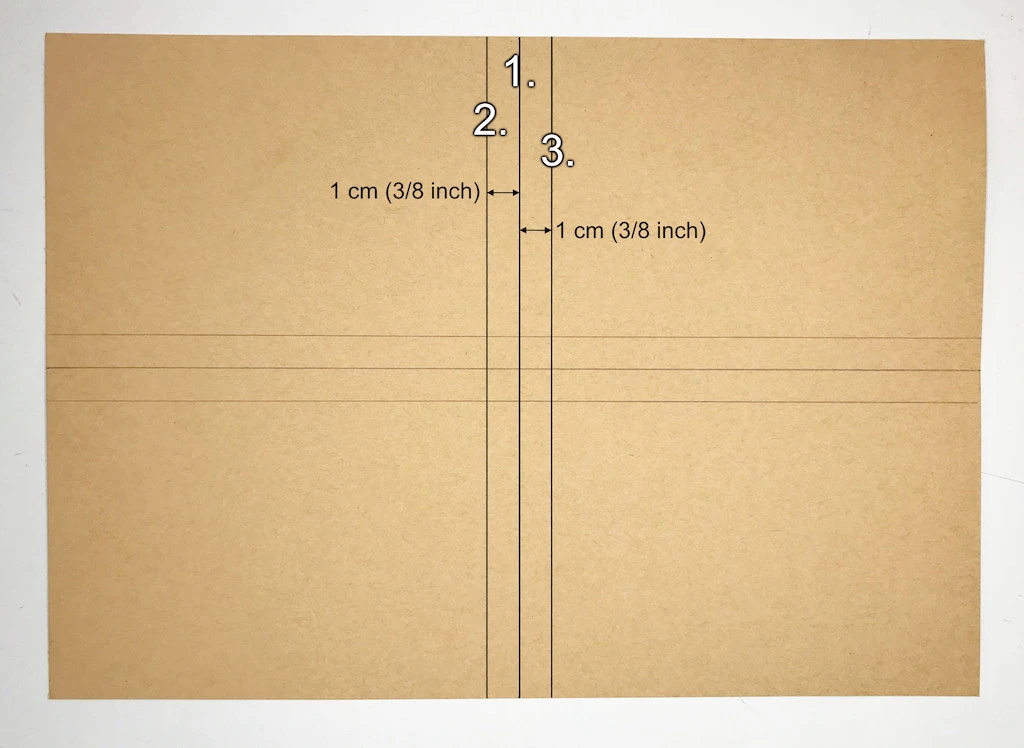 Drawing three vertical parallel lines on kraft paper.