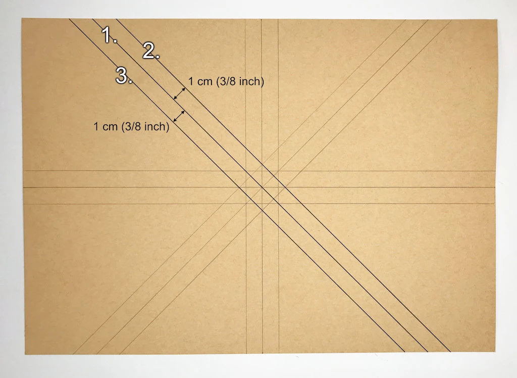 Drawing another set of three diagonal lines on kraft paper.