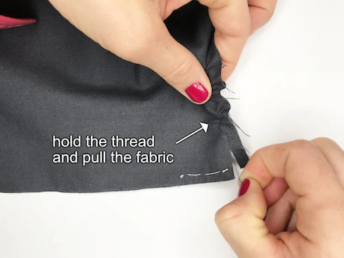 Pulling the fabric along the picked thread.