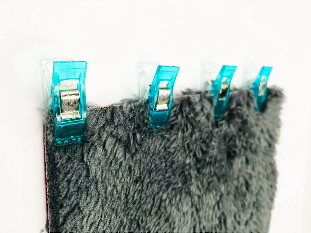 Two pieces of fabric pinned together with sewing clips.