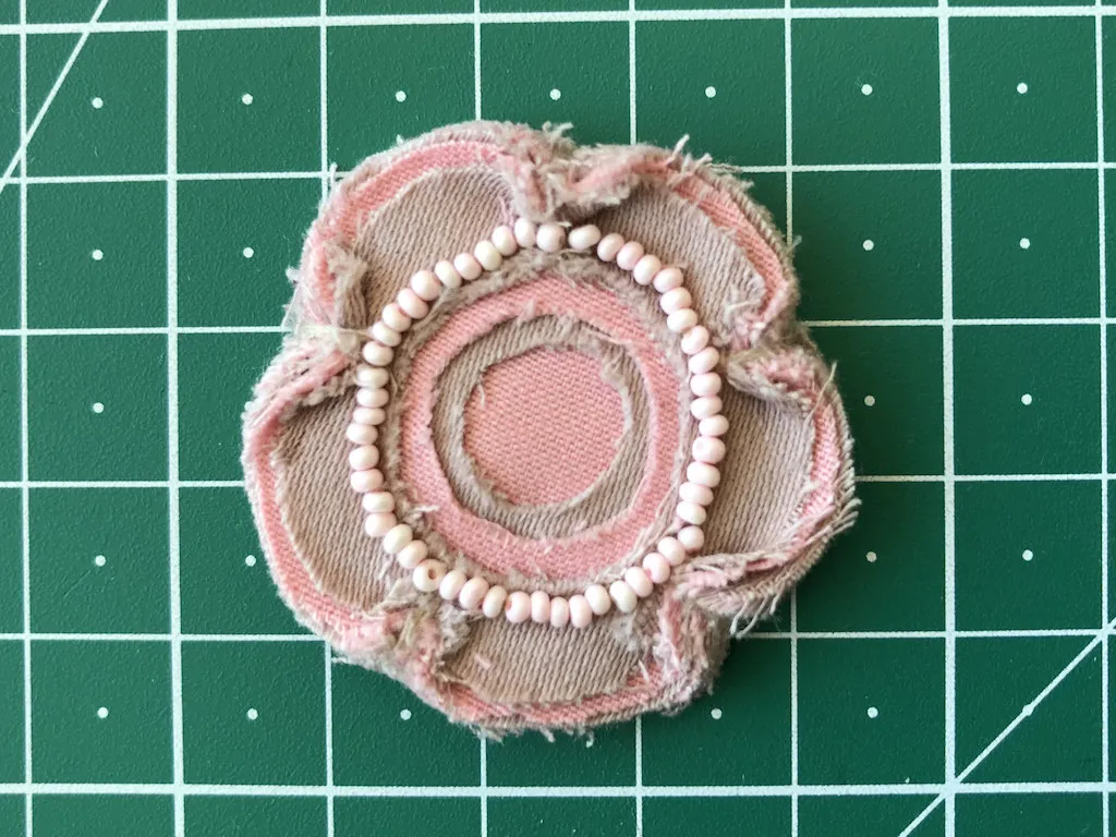 Small flower applique with beaded embellishment.