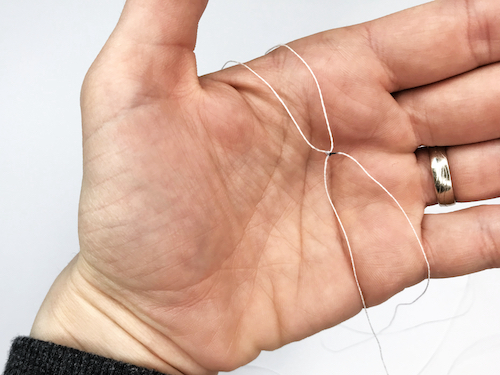 Tied knot on a string that will set the radius at hem for the circle skirt pattern.