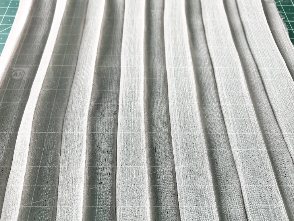 Creased permanently pleated chiffon fabric. Accordion pleats.