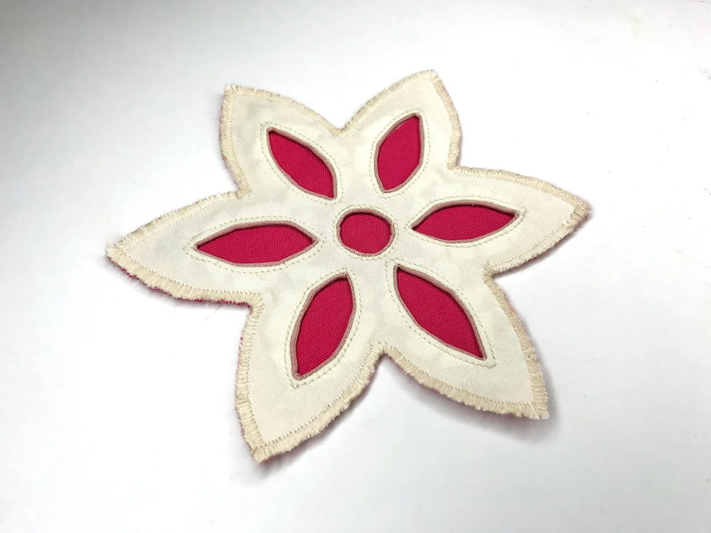 A reverse applique with a dense zigzag stitch used to finish its edges.
