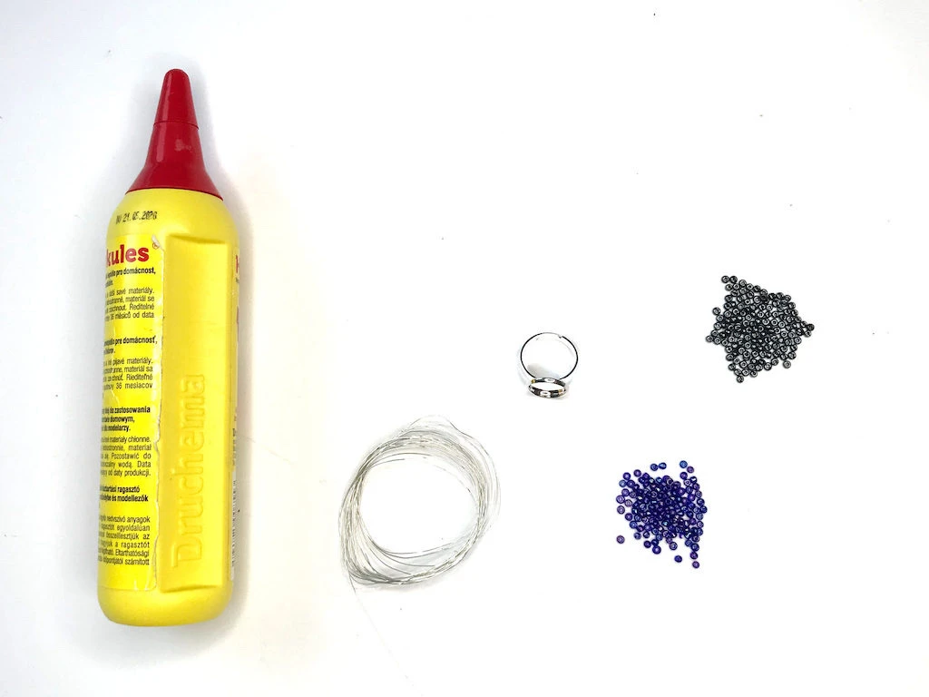 Glue, wire, blue and black beads, ring needed to make a DIY Luna Lovegood beetle ring.