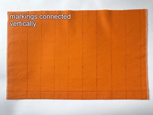 Vertical lines on a piece of fabric that will be folded to shape box pleats.