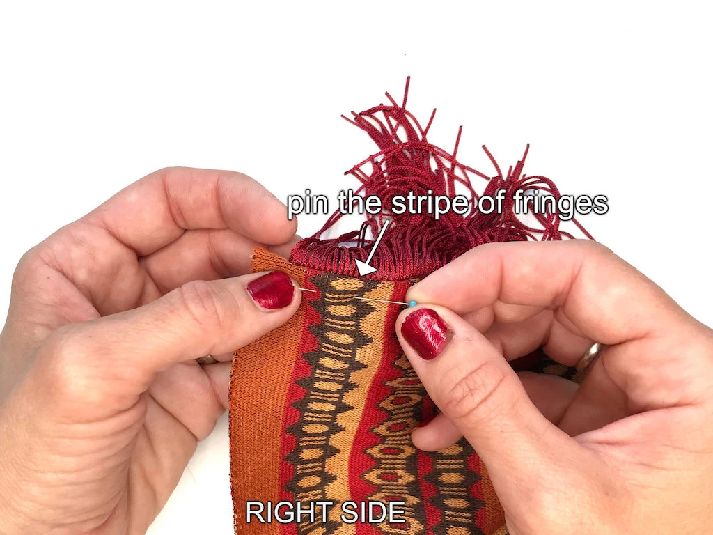 Pinning fringes with fabric so that they can be topstitched.