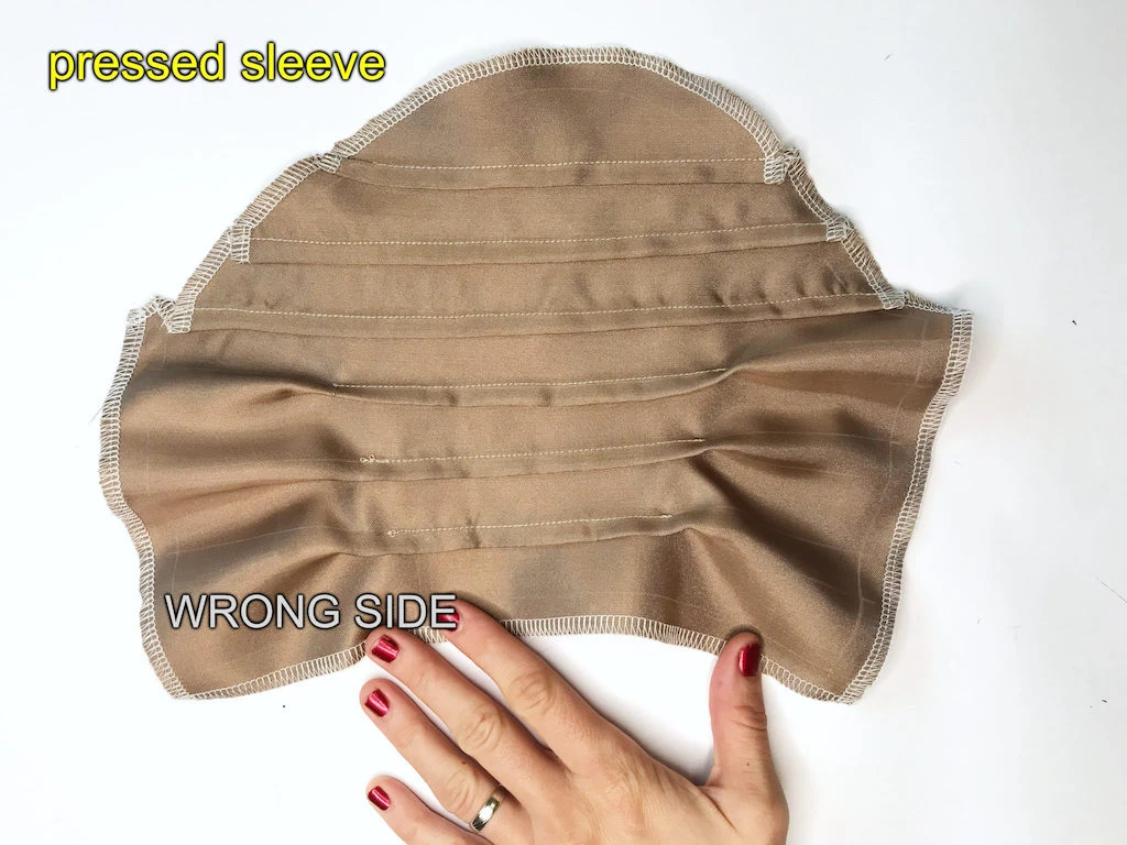 Pressed beige set-in satin sleeve with tucks on the wrong side.