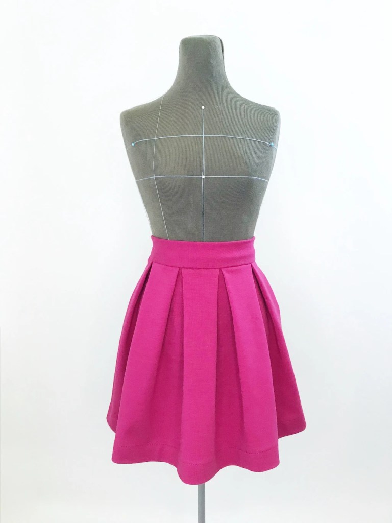 Pink knit jersey skirt with box pleats.