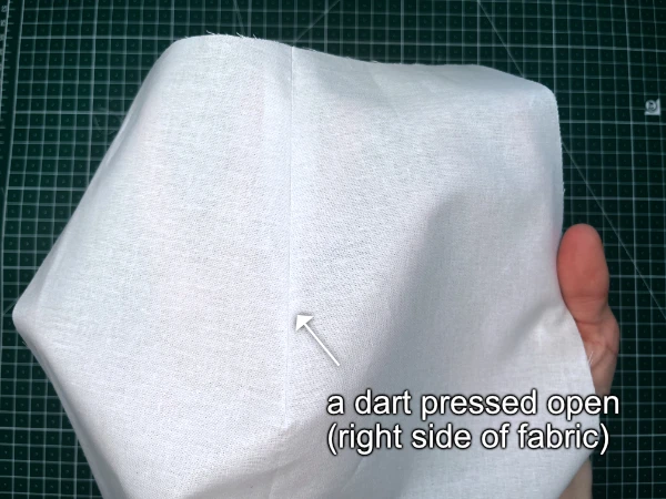 Darts in sewing patterns: dart with its bulk trimmed away pressed open.