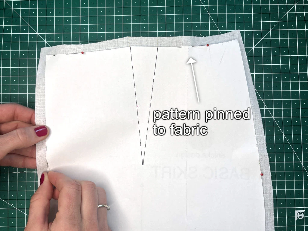 Pinning a sewing pattern to fabric.