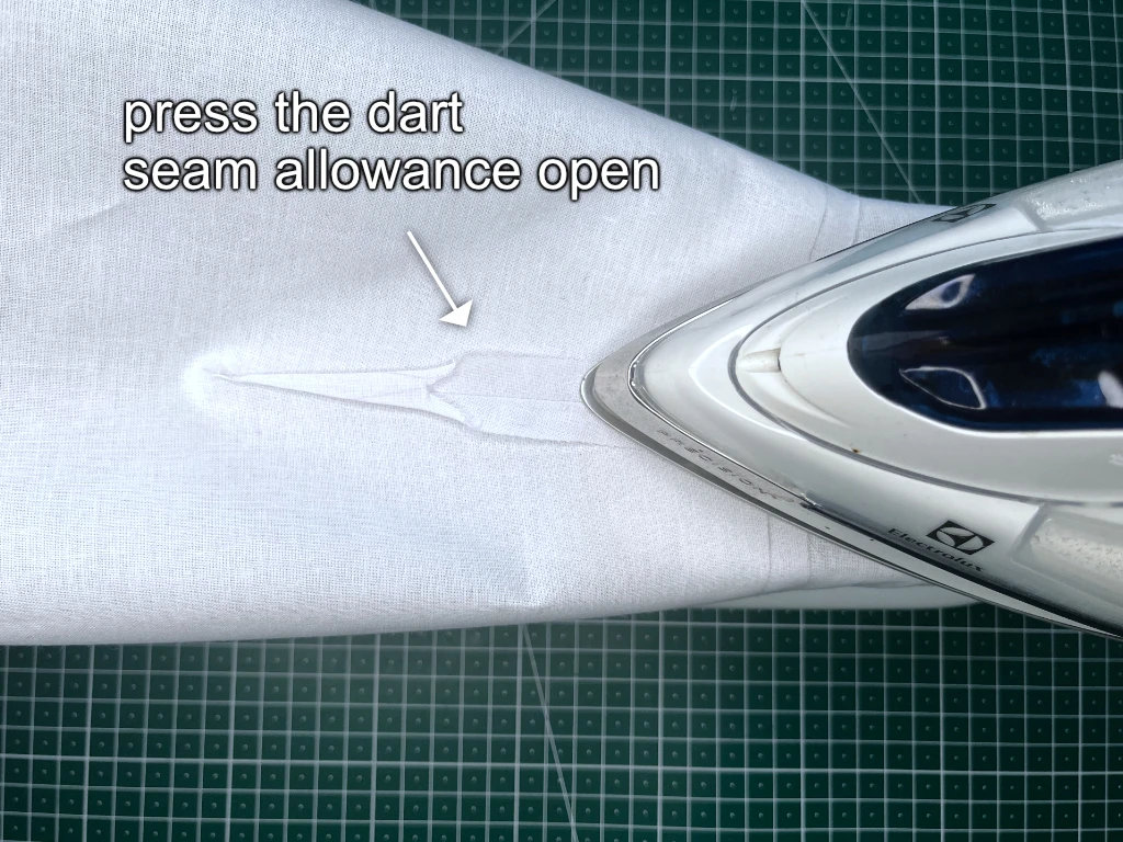 Pressing the seam allowance on a trimmed dart open.